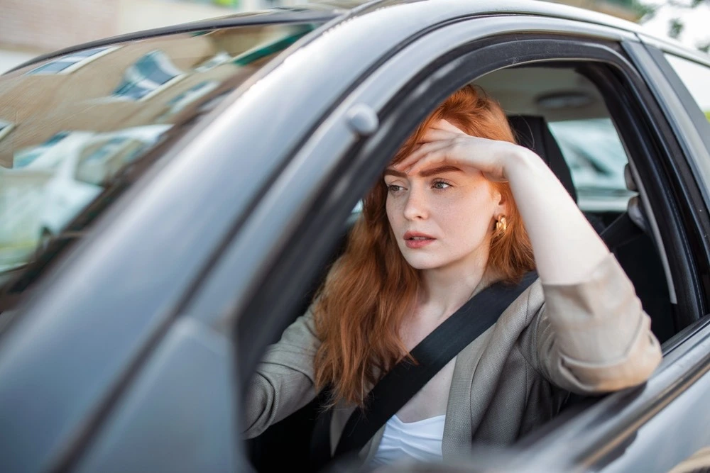 A serious person behind the wheel, symbolizing moving forward in life after participating in a rehabilitation program